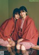 A couple of women sitting on top of a wooden bench.