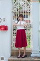 A woman standing in front of a white gate.