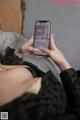 A woman laying on a bed holding a cell phone.