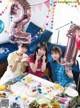 A group of young girls sitting at a table with balloons.